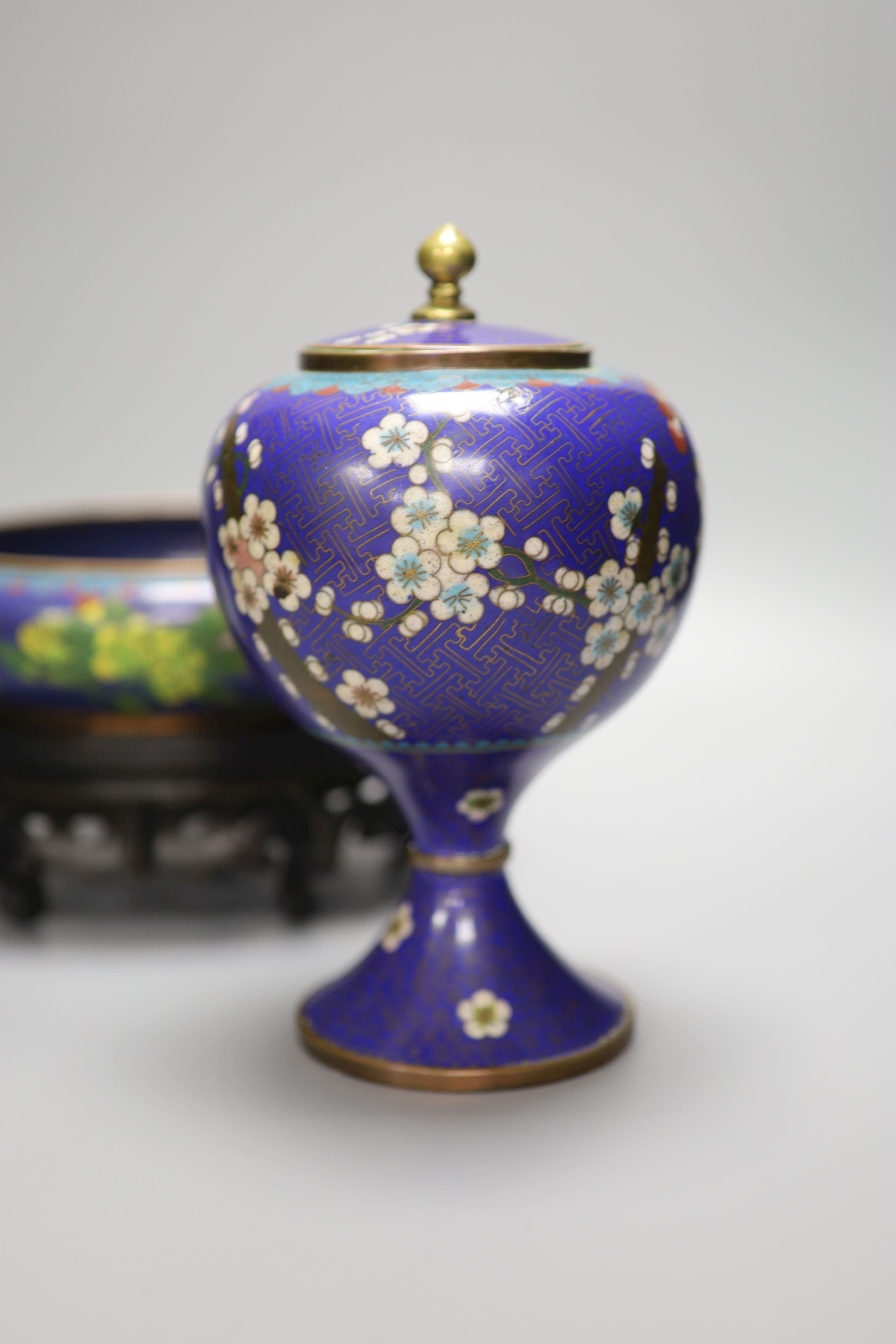 A pair of early 20th century Chinese cloisonne enamel jars and covers and a similar bowl and wood stand, tallest 20cm